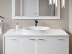 a white bathroom sink sitting under a large mirror