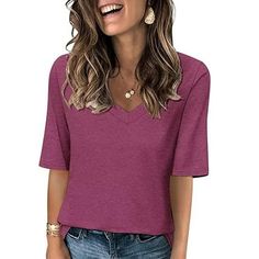 a woman wearing a purple shirt and jeans