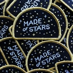 black and gold embroidered stars with words made of stars written in white on the back