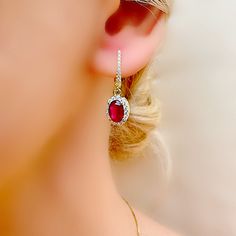 Adorn yourself in the timeless allure of these stunning genuine ruby dainty halo dangle drop earrings, exquisitely crafted in sterling silver 925 and electroplated in 18 carat gold for a luxurious finish (gold vermeil). Each ruby gemstone, elegantly suspended within its halo setting, captures the ruby essence of July, making these earrings a meaningful gift for those celebrating their birth month or the cherished 40th wedding anniversary. Surrounded by a shimmering array of micro white topaz sto Elegant Ruby Halo Jewelry, Halo Ruby Jewelry, Elegant Ruby Earrings With Halo Setting, Oval Ruby Earrings With Halo Design, Red Ruby Drop Earrings, Hallmarked Ruby Drop Earrings, Ruby Halo Earrings, Anniversary Silver Earrings With Lab-created Ruby, Oval Red Ruby Earrings