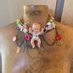 a mannequin with a baby on it's back and lots of beads