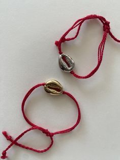 handmade summer themed lucky red string bracelet with gold/silver cowrie shell charm and adjustable size. Handmade Cowrie Shell Friendship Bracelets As Gift, Red Friendship Bracelets For Beach, Red Adjustable Friendship Bracelets For Beach, Red Adjustable Friendship Bracelets For Summer, Handmade Red Braided Bracelets For Beach, Red Beach Jewelry With Sliding Knot, Handmade Red Braided Bracelet For Beach, Red Bracelet Jewelry For Vacation, Resizable Red Jewelry For Beach