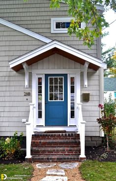 a blue front door on a house with steps leading up to the porch and side entrance