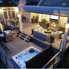 a hot tub sitting on top of a wooden deck next to a patio with lights