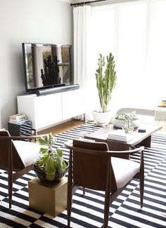 a living room filled with furniture and a flat screen tv on top of a wooden table