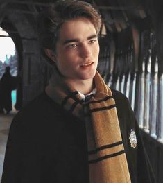 a young man wearing a harry potter scarf