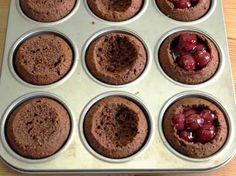 chocolate cupcakes with cherries in a muffin tin