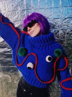 "Introducing the \"Monstrously Chic\" handmade chunky sweater - because who said winter fashion can't be a laugh riot? This blue delight is rocking a rebellious red line pattern, and thanks to two mischievous pom-poms, it's basically a cute monster from a parallel universe. Because who needs ordinary when you can have a sweater that's anything but? Stay cozy, stay quirky!  Please be patient, as this sartorial masterpiece requires two weeks of craftsmanship before it embarks on its journey to your wardrobe. Quality takes time, but rest assured, the wait is worth it for a uniquely tailored touch to your winter style. Sweater comes with 4 pom-poms, 2 in green and 2 eyes." Knitted Blue Cropped Sweater For Winter, Blue Knitted Cropped Sweater For Winter, Chunky Knit Blue Knitting Pattern For Fall, Fall Blue Chunky Knit Pattern, Winter Blue Yarn Knitting Pattern, Winter Knitting Pattern In Blue Yarn, Blue Yarn Knitting Pattern For Winter, Oversized Hand Knitted Blue Sweater, Oversized Hand-knitted Blue Sweater