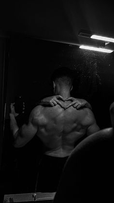 a shirtless man taking a selfie in front of a mirror with his hands on his chest