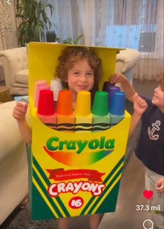 a young child holding up a crayon box costume