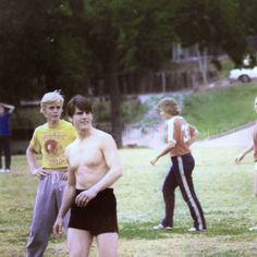 a group of young men standing next to each other on top of a lush green field