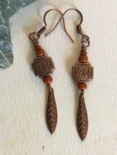 These dangle earrings have a Southwestern flair with the tribal copper beads as the main focus. Added to the copper bead are adobe colored Toho glass seed beads. They have a copper feather dangle to go with the theme. They are very lightweight and use an earwire to hang. Bohemian Brown Beaded Nickel-free Earrings, Bohemian Brown Copper Wire Jewelry, Artisan Copper Beaded Drop Earrings, Bohemian Rust Earrings With Ear Wire, Rust Bohemian Earrings For Pierced Ears, Southwestern Brown Copper Jewelry, Bohemian Beaded Copper Earrings, Bohemian Rust-colored Nickel-free Earrings, Bohemian Nickel-free Rust Earrings