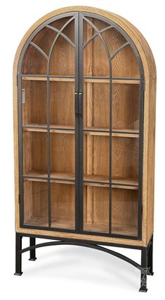 an arched wooden bookcase with glass doors and metal frame, on display in front of a white background