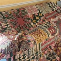 a bed covered in a colorful quilt next to a window