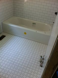 a bathroom with a white tub and tiled floor