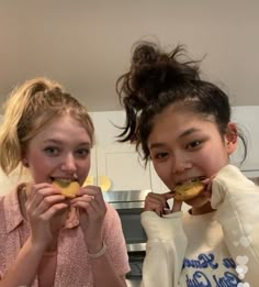 two girls are eating donuts in the kitchen