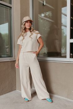 Look super cute and feel comfortable all day in THE SARA SET IN CREAM! This travel outfit includes a raw hem, cropped short sleeve sweater and wide leg pants with an elastic waist. Perfect for wearing all day, this set is both stylish and comfortable. Paired with THE HOWDY DARLIN' TRUCKER HAT IN BEIGE & THE FIERCE SNEAKERS IN GREEN Sold as a set. Top: Short sleeve Round neck Raw hem Slightly cropped Loose fit 80% polyester, 20% spandex Bottom: Wide leg Pockets Relaxed fit Elastic waistband Raw h Summer Cotton Cream Set, Casual Cropped Sets For Day Out, Casual Wide Leg Sets For Day Out, Beige Cotton Daywear Sets, Casual Cream Sets For Playwear, Summer Cropped Wide Leg Pants For Loungewear, Summer Cropped Wide Leg Loungewear Pants, Cropped Wide Leg Summer Loungewear Pants, Summer Cropped Wide Leg Lounge Pants