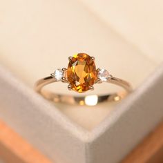 an orange and white diamond ring in a box