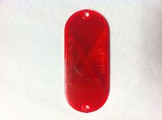 a red stop light sitting on top of a white surface