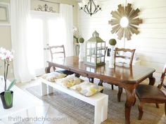 a dining room table and chairs with sunburst decoration on the wall behind it