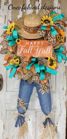 a scarecrow with sunflowers and a happy fall sign hanging on a door