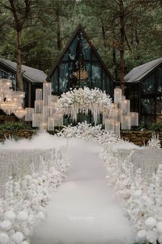 an outdoor ceremony with white flowers and chandeliers