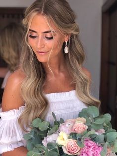 a woman holding a bouquet of flowers in her hands