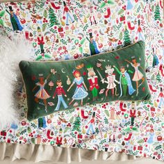 a decorative pillow on top of a bed next to a stuffed animal and christmas decorations