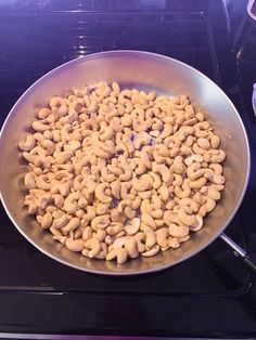 a pan filled with cashews sitting on top of an oven