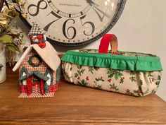 two christmas decorations sitting on top of a table next to a clock