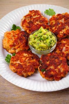 a white plate topped with chicken cutlets and guacamole