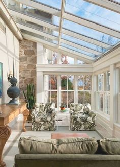 a living room filled with furniture under a glass roof