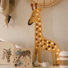 a toy giraffe is sitting on a shelf next to other toys and decorations