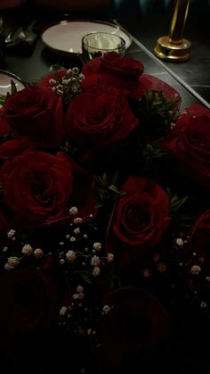 a bouquet of red roses sitting on top of a table