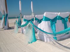 the beach is decorated with white and turquoise linens