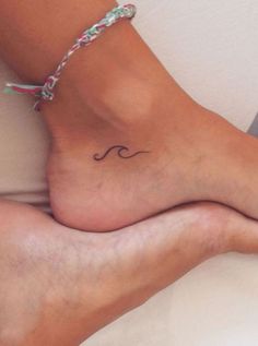 a woman's foot with a wave tattoo on it