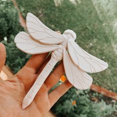 a hand holding a small white dragon figurine