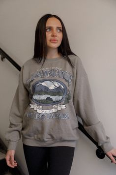 Experience the beauty of nature with our Washington Mount Rainier sweatshirt. Inspired by vintage designs, this graphic sweatshirt showcases the majestic Mount Rainier in soft shades of grey. Perfect for outdoor enthusiasts and fashion lovers alike. distressed vintage inspired graphic long sleeves crew neck relaxed fit model is wearing a s/m Gray Cotton Outdoor Sweatshirt, Gray Sweatshirt For Outdoor Fall Activities, Outdoor Long Sleeve Graphic Sweater, Oversized Gray Sweatshirt For Outdoor, Fall Hiking Crew Neck Sweatshirt, Fall Hiking Sweatshirt Crew Neck, Fall Crew Neck Sweatshirt For Hiking, Fall Hiking Sweatshirt With Letter Print, Gray Crew Neck Sweatshirt For Outdoor Activities