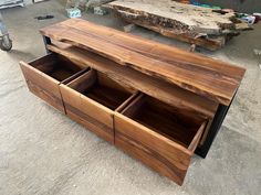 a wooden table with drawers sitting on top of it's sides in a warehouse