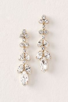 two pairs of gold tone earrings with crystal stones on each side and dangling from the back