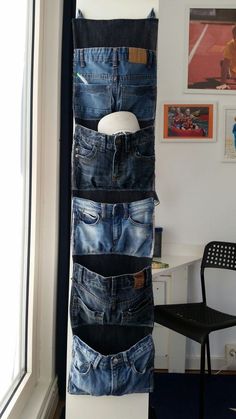 a stack of jeans hanging from the side of a wall