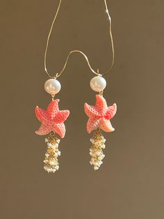 Joyful summer earrings, ideal for a beach vacation! Two starfish are made of carved conch shell, adorned with cascade of tiny fresh water pearls. The pearl studs are 18k gold filled.  MATERIAL Conch shell, freshwater pearls, gold filled   SPECIFICATIONS Length 6 cm Handmade in Spain Earrings come in a gift box Worldwide shipment with registered, trackable post Care for gold filled jewelry: avoid contact with humidity, swimming pool water and chemicals. Clean with soft dry polishing cloth.  Care Summer Earrings With Starfish Charm, Ocean-inspired Starfish Charm Earrings, Summer Starfish Charm Drop Earrings, Ocean-inspired Drop Earrings With Starfish Charm, Summer Shell Starfish Jewelry, Dangle Earrings For The Beach, Summer Starfish Shell Jewelry, Pierced Dangle Earrings For Beach, Handmade Starfish Earrings For Beach