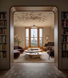 a living room filled with lots of furniture and bookshelves next to a window