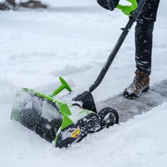 a person using a snow blower to clear the snow