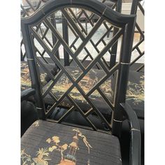 a set of four black chairs with floral upholstered backrests and seat cushions