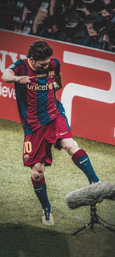 a man kicking a soccer ball on top of a field