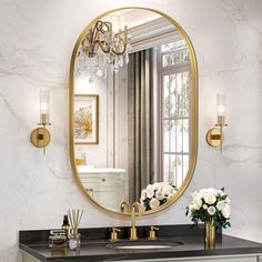 a bathroom with marble counter tops and gold fixtures, along with a round mirror above the sink