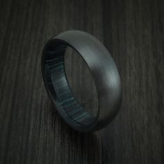 Black Zirconium and Indigo Wood Hard Wood Sleeve Ring Custom Made | Revolution Jewelry Designs Black Titanium Anniversary Rings, Black Titanium Round Jewelry, Black Promise Ring With Polished Finish, Black Titanium Jewelry With Polished Finish, Formal Black Titanium Jewelry, Zirconium Ring, Black Titanium Ring, Black Zirconium Ring, Titanium Rings For Men