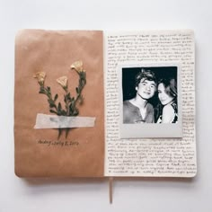 an open book with two photos and flowers on the pages, next to each other