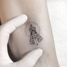 a small tattoo on the arm of a woman's left arm, with two bells